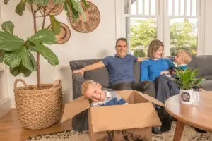 happy family sitting on couch with moving boxes