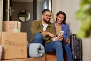 smiling couple booking moving services on phone