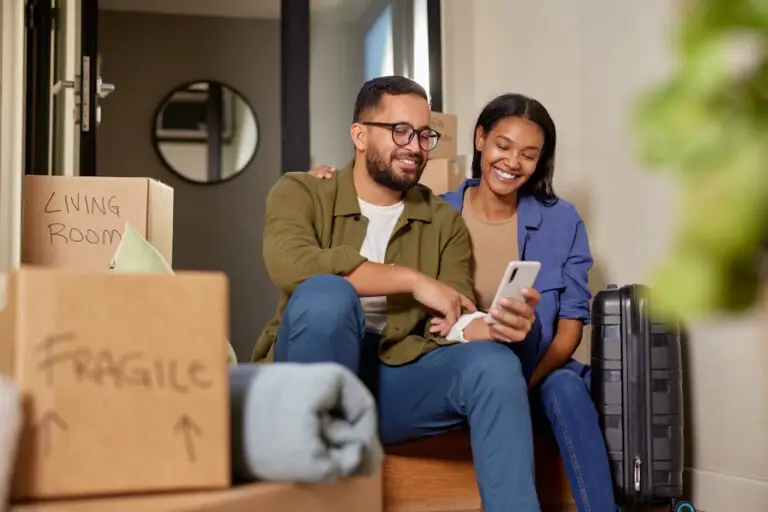 smiling couple booking moving services on phone