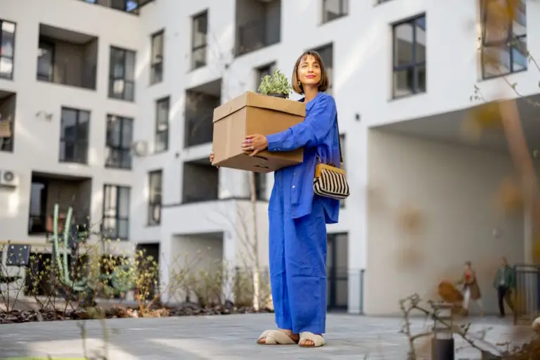 woman with moving box outside apartment